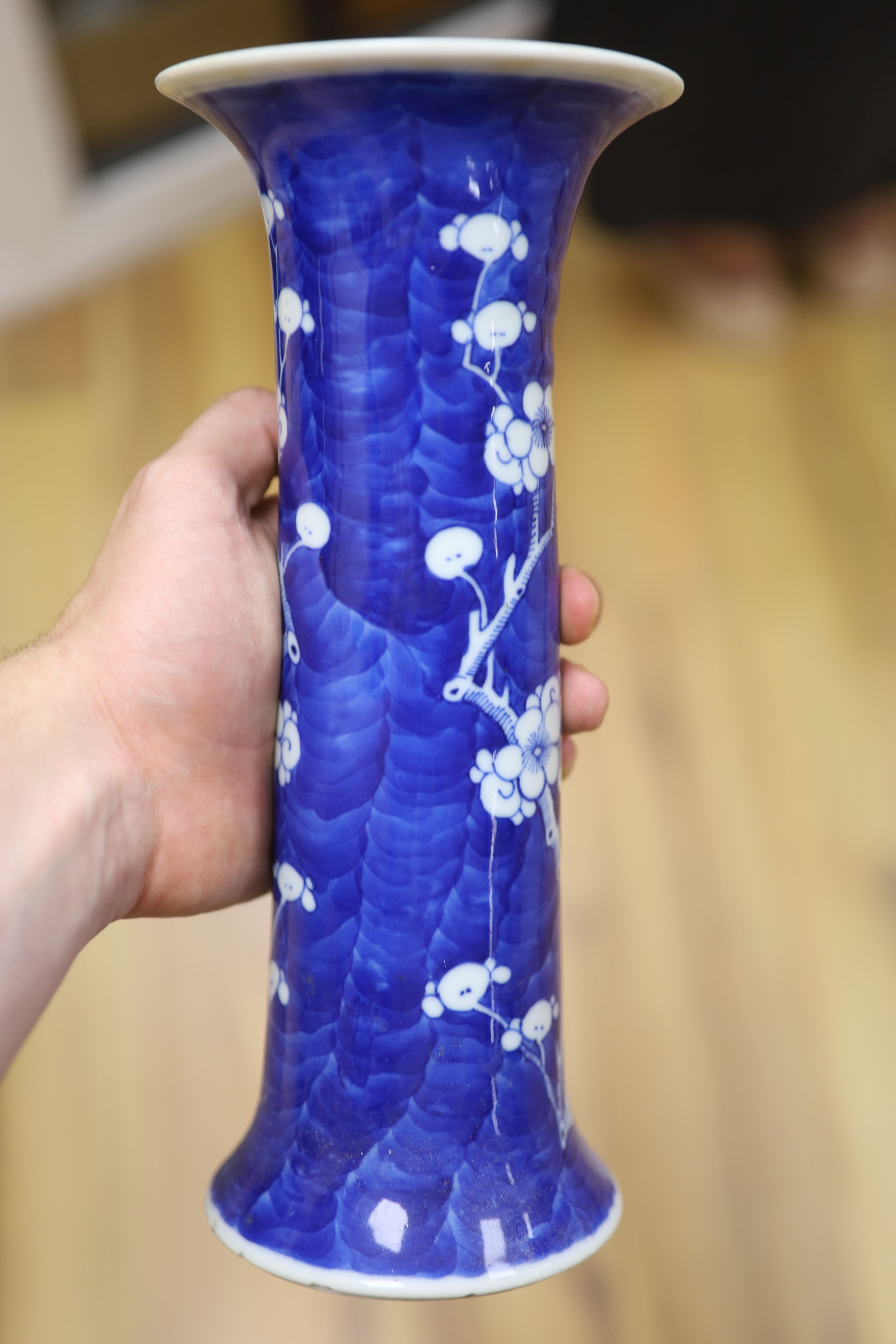 Two Chinese blue and white prunus pattern ginger jars and a similar cylinder vase, tallest 26cm